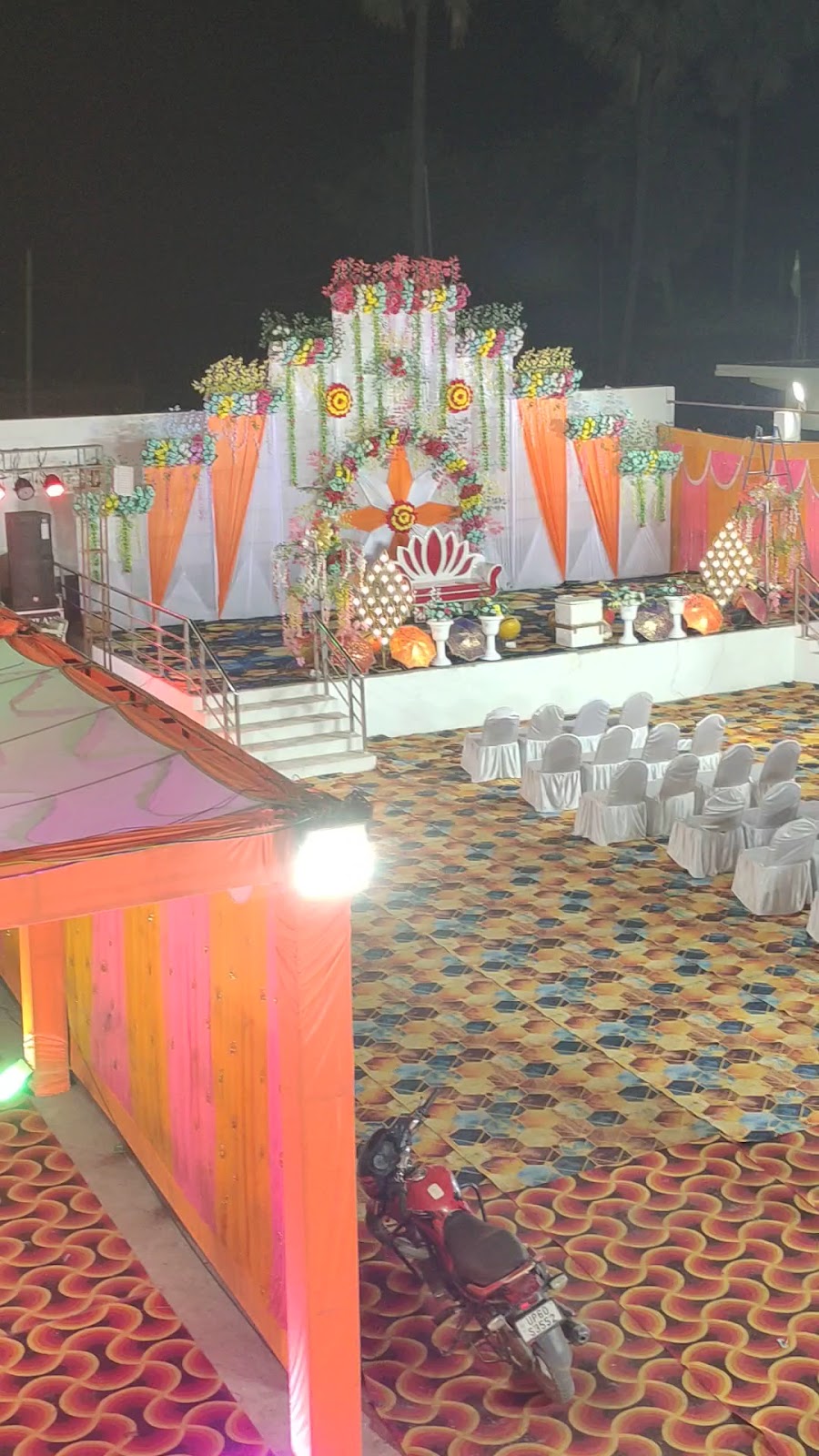 पेवर ब्लॉक वाला खुला लॉन, कुर्सियाँ और ढका पंडाल